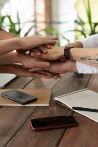 Mains jointes en signe de cohésion de l'équipe lors d'un atelier de sensibilisation aux handicaps en entreprise.